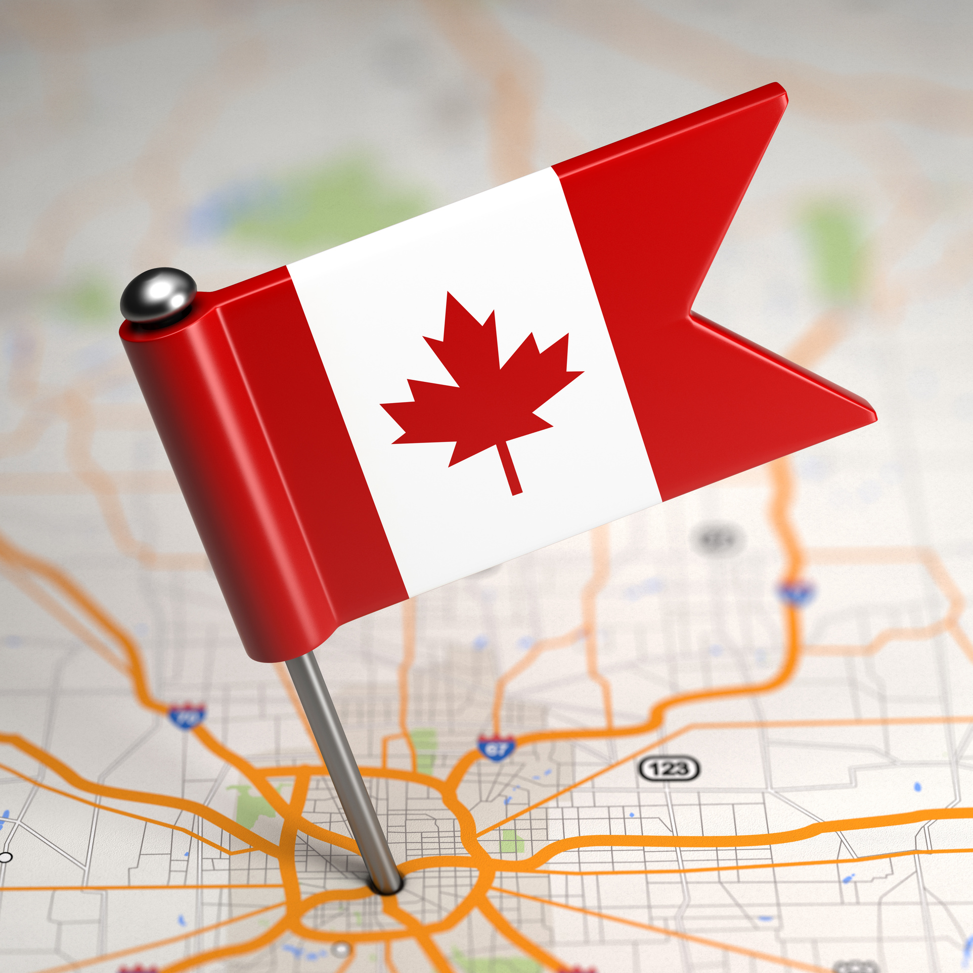 Small Flag of Canada on a Map Background with Selective Focus.